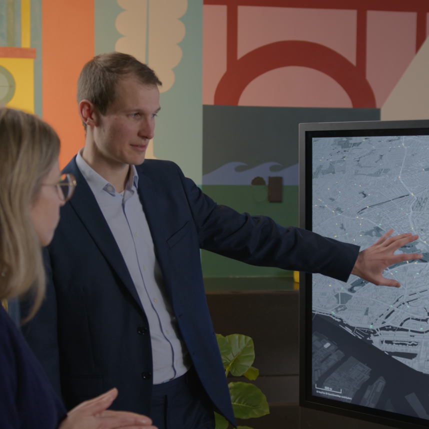 ein MOIA Berater zeigt auf die Mobility Impact Analyzer Simulation